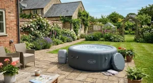 A round affordable inflatable spa set up on a paving stone patio in a traditional British back garden